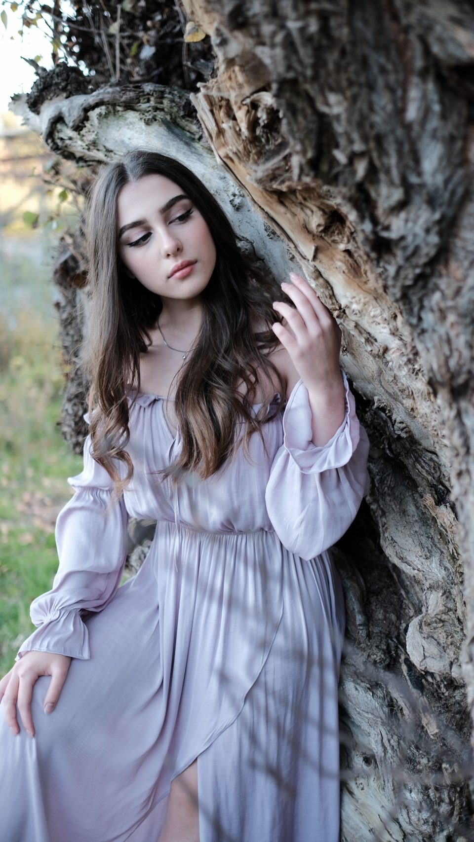 身着紫色长裙依靠在枯木旁的美女写真