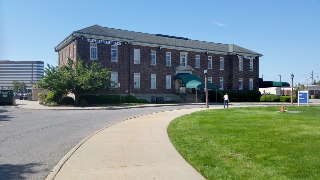 蓝天下绿色草坪边上马路和房屋建筑