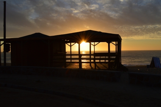夕阳下大海边小木屋的黑色剪影