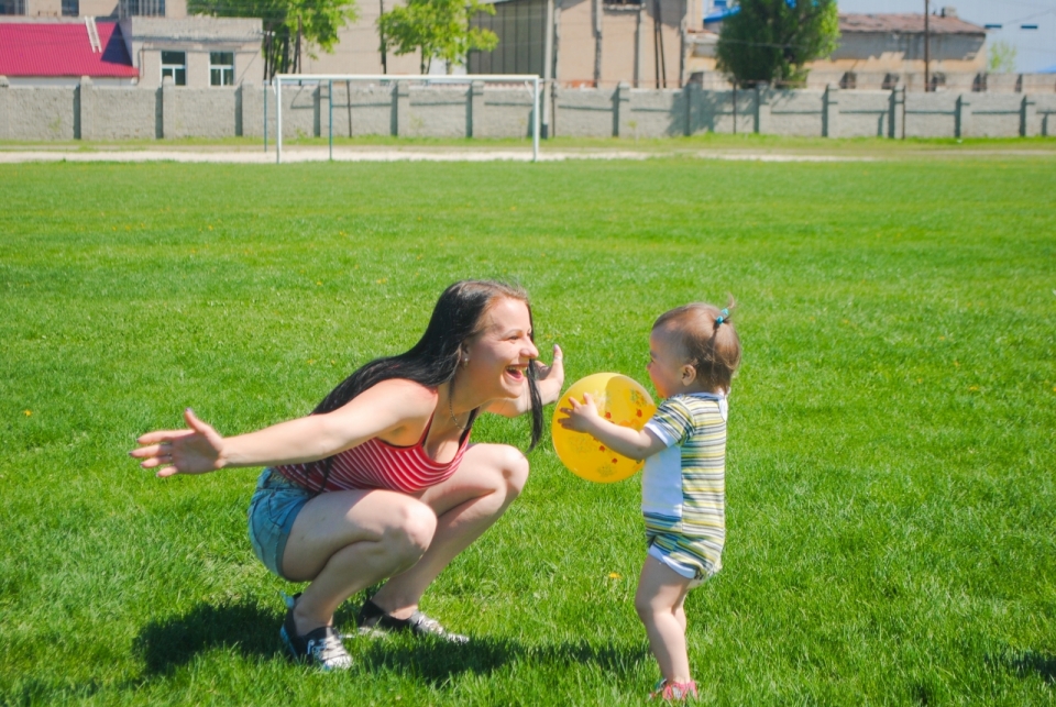 阳光户外绿色草坪足球场游玩开心母子