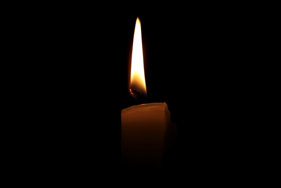 黑暗中一只燃烧的白色蜡烛