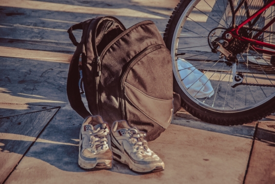 阳光城市街道自行车边黑色背包运动鞋