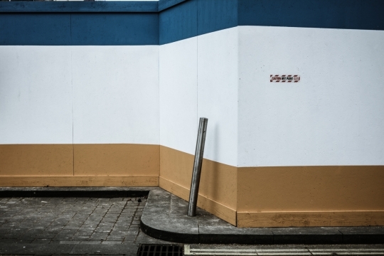 街道蓝色白色黄色相间墙壁旁木棍