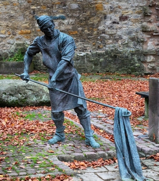 路边穿着围裙手拿铁钩钩布匹的人物雕像