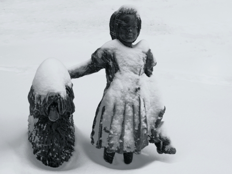 冬天雪地上黑色小女孩和外星人雕塑玩偶