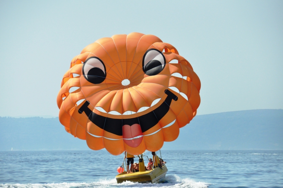 明媚阳光大海上的快艇和笑脸降落伞