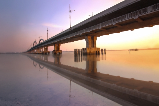日出阳光桥梁倒映湖泊湖面