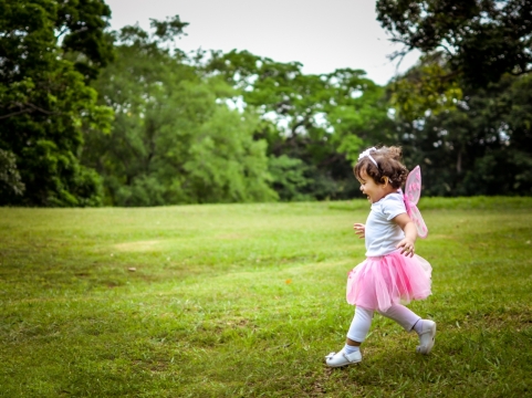 奔跑在绿色草坪上的小女孩