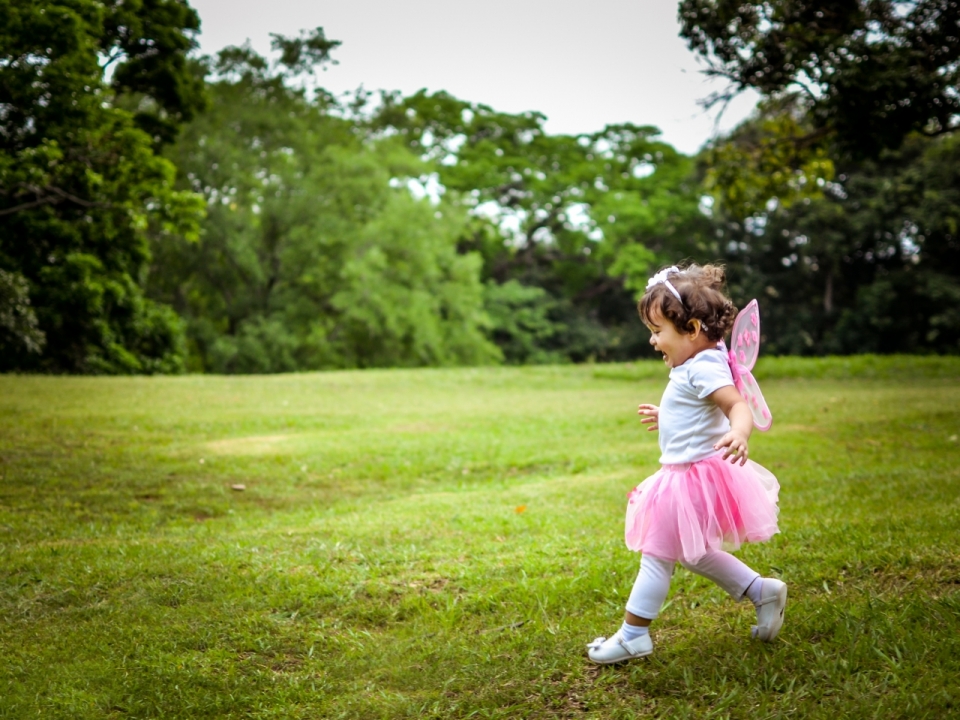 奔跑在绿色草坪上的小女孩