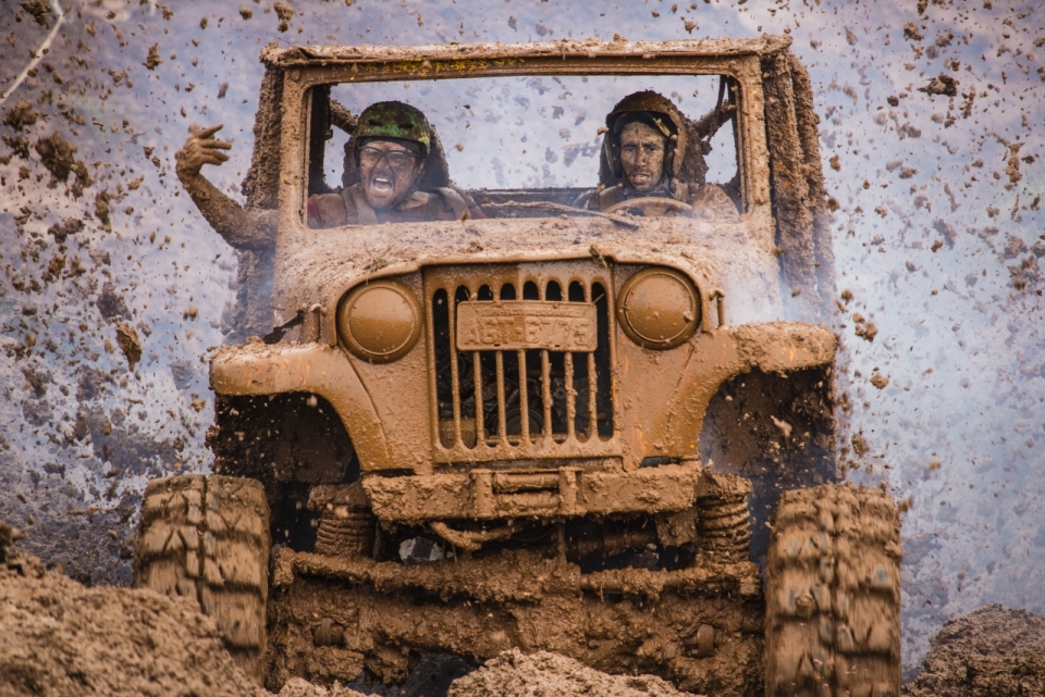 两个驾驶越野车在泥泞土地上行驶的男人