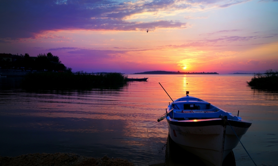 夕阳西下晚霞和湖泊旁的小船