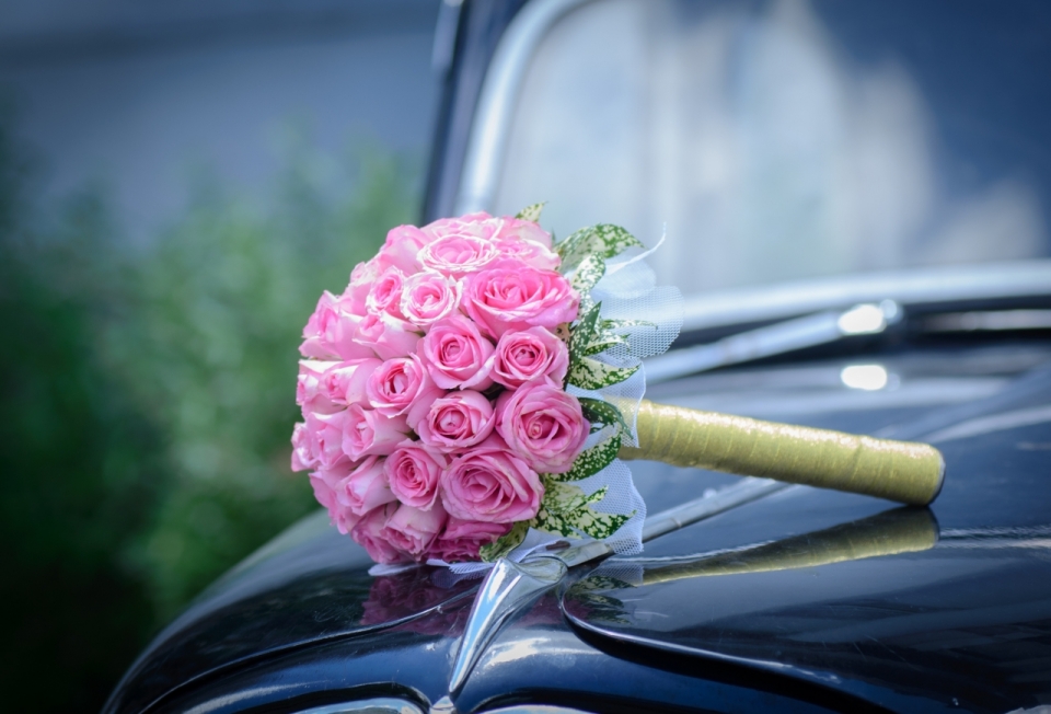 背景虚化汽车上的粉色玫瑰花束