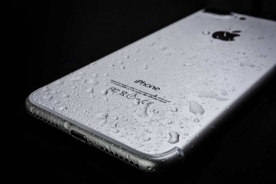 黑色背景沾水崭新银色iPhone智能手机