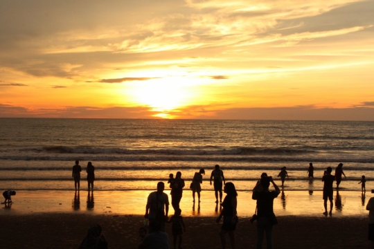 傍晚阳光天空下大海海面游客们