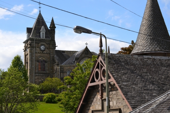 蓝天白云尖顶建筑绿树风光