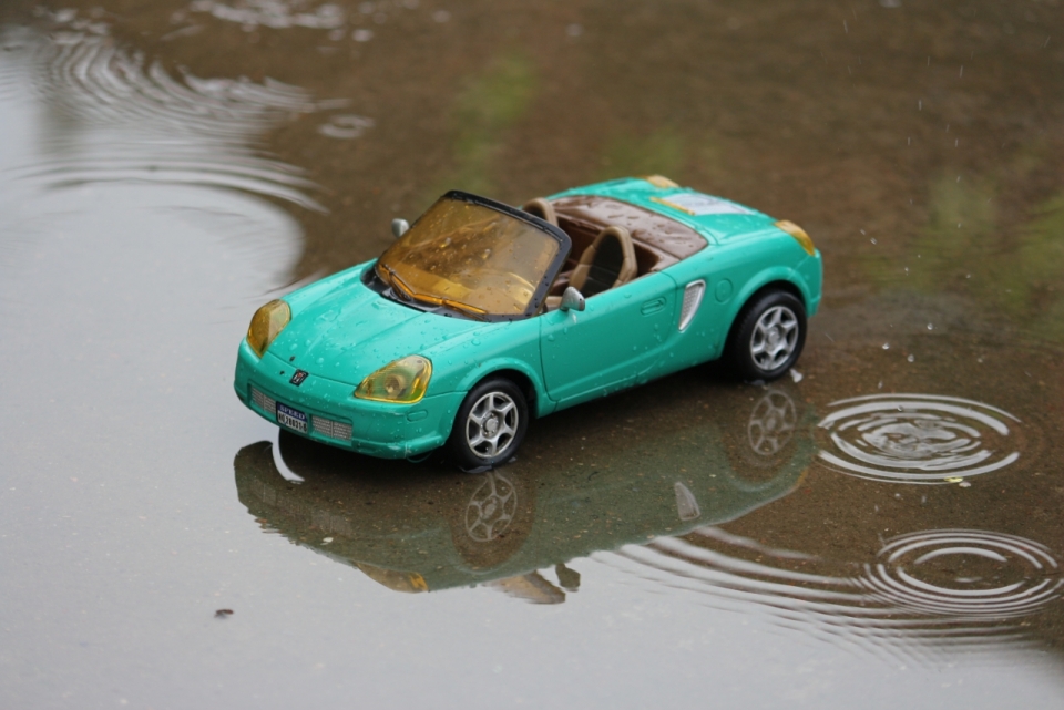 雨天水塘中的绿色跑车模型摄影