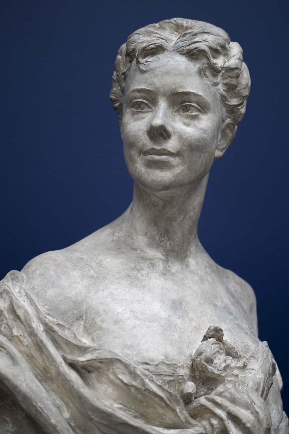 蓝色背景优雅短发女性艺术石质雕像
