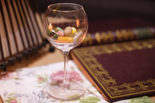 室内桌面文艺书本前玻璃高脚杯中胶囊