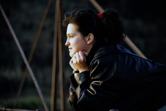 阳光户外黑色皮衣时尚美女侧面