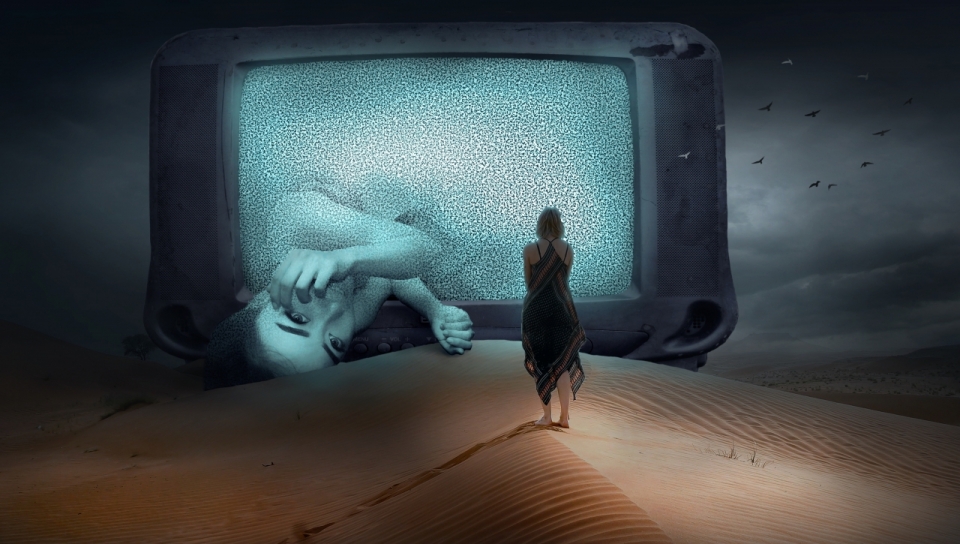 女子行走在沙漠上面对巨型电视中睡倒的女人