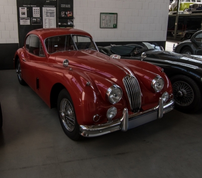 城市街道建筑前老式红色捷豹轿车