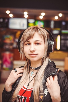 虚化背景夜晚室内戴黑色耳机时尚金发女性