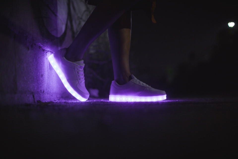 黑夜中的街角散发着紫色光亮的鞋子