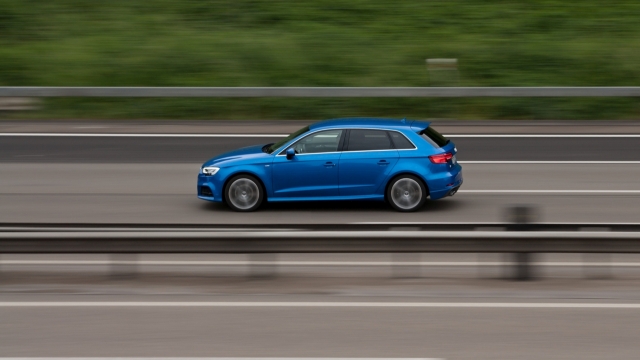 城市高速公路疾驰蓝色崭新轿车