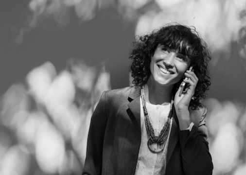 黑白戴项链卷发女性手机打电话