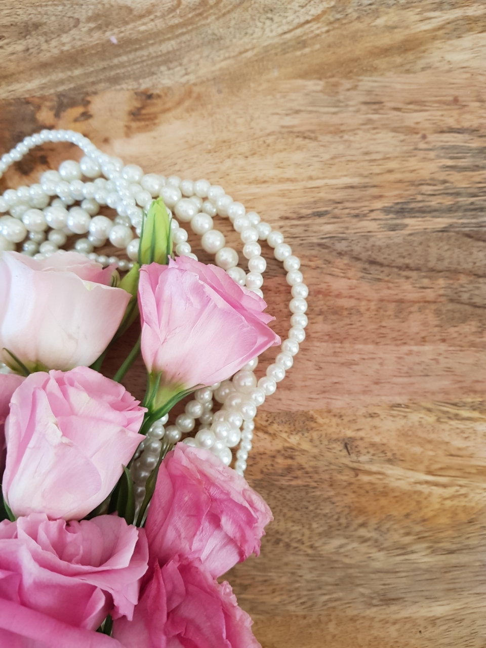 木制桌面粉色花朵玫瑰植物珍珠项链