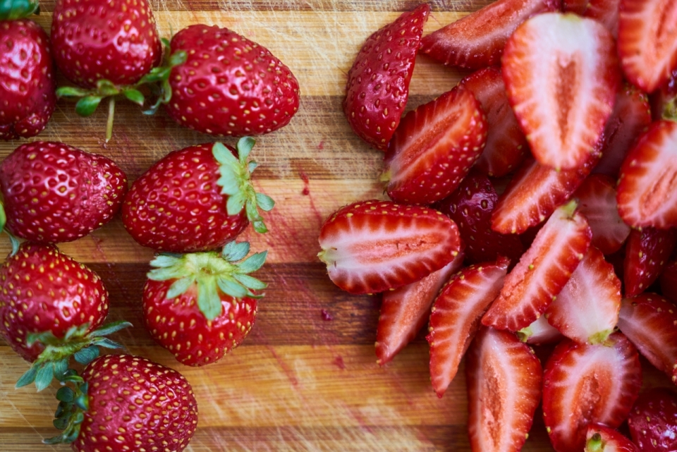 木桌上新鲜成熟饱满的草莓水果摄影
