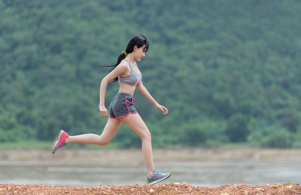 身材性感的运动装健身美女在河边跑步