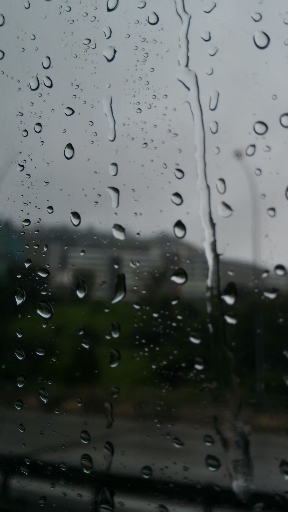 雨天雨水落在汽车车窗玻璃上的摄影
