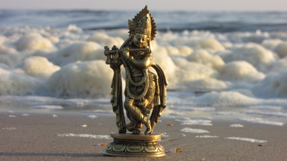 微距摄影_海边沙滩的青铜佛像
