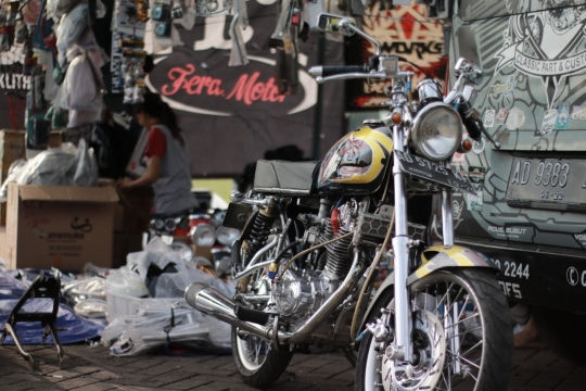 女性在有着复古摩托车的车店仓库工作