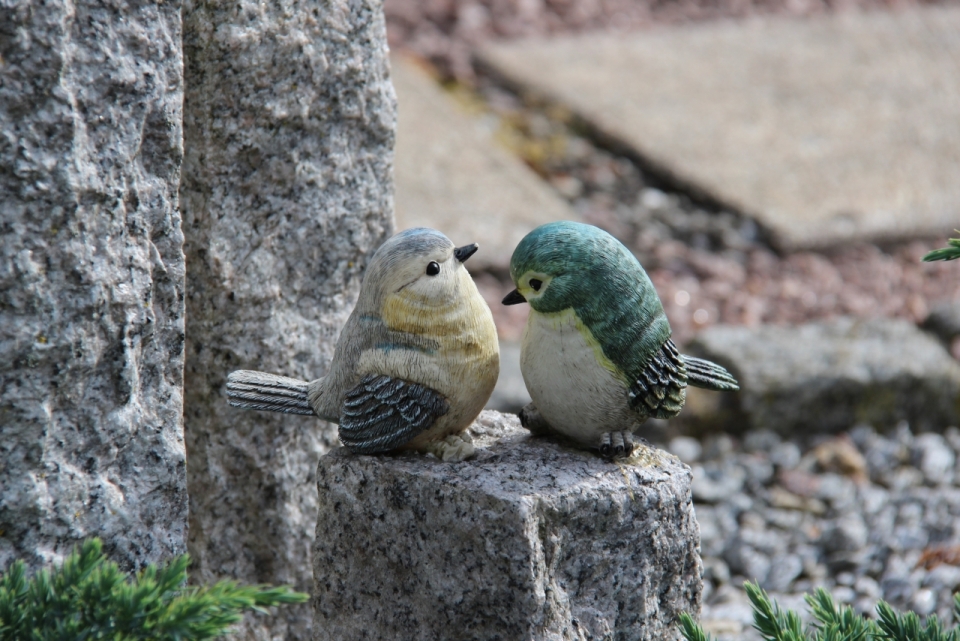 户外自然岩石上彩色鸟类动物雕刻模型