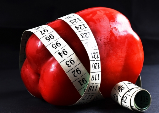 黑色背景软尺环绕新鲜红色菜椒