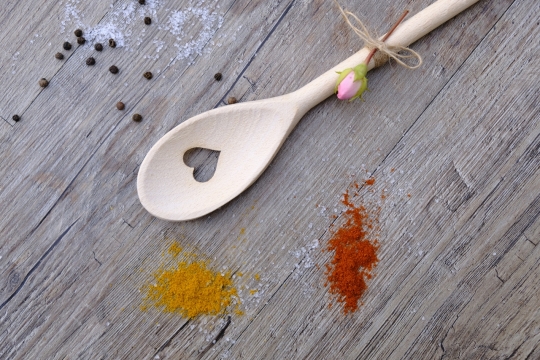 木桌上散落的香料和带着心形破孔的勺子