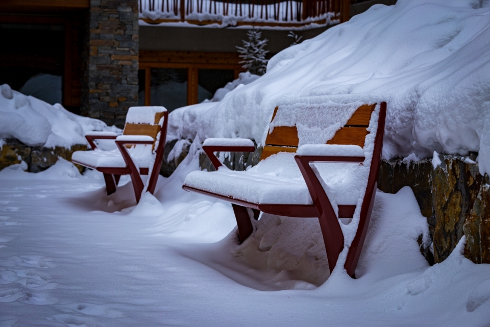 路边被厚厚积雪覆盖的木质长凳