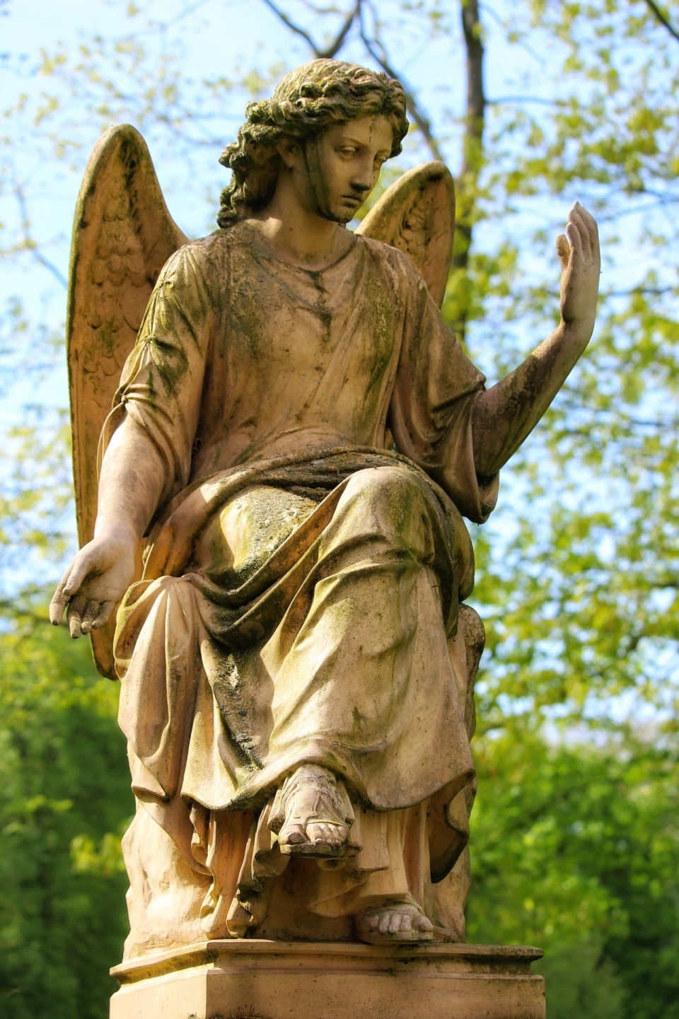 小镇树林旁阳光照射天使人物雕塑