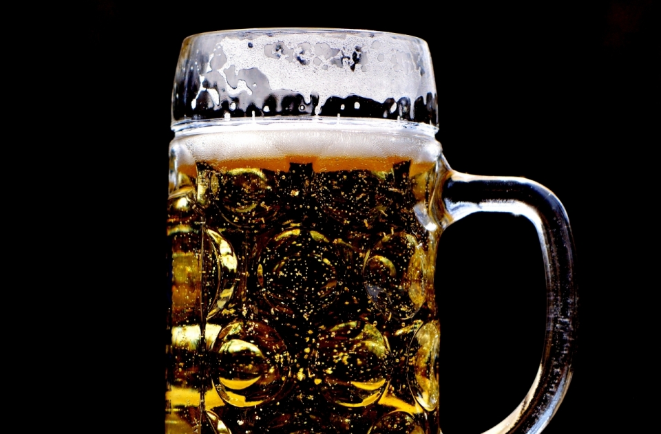 杯中的啤酒在黑色背景下创意摄影