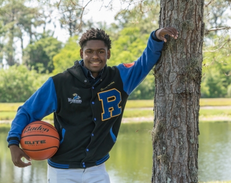 阳光自然户外树木边抱篮球黑人男性