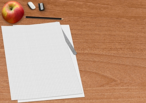 木桌上的文具方格纸和苹果背景素材