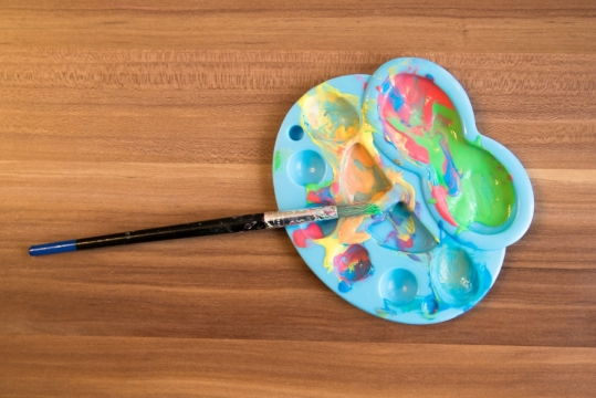 木制桌面彩色颜料蓝色调色盘画笔