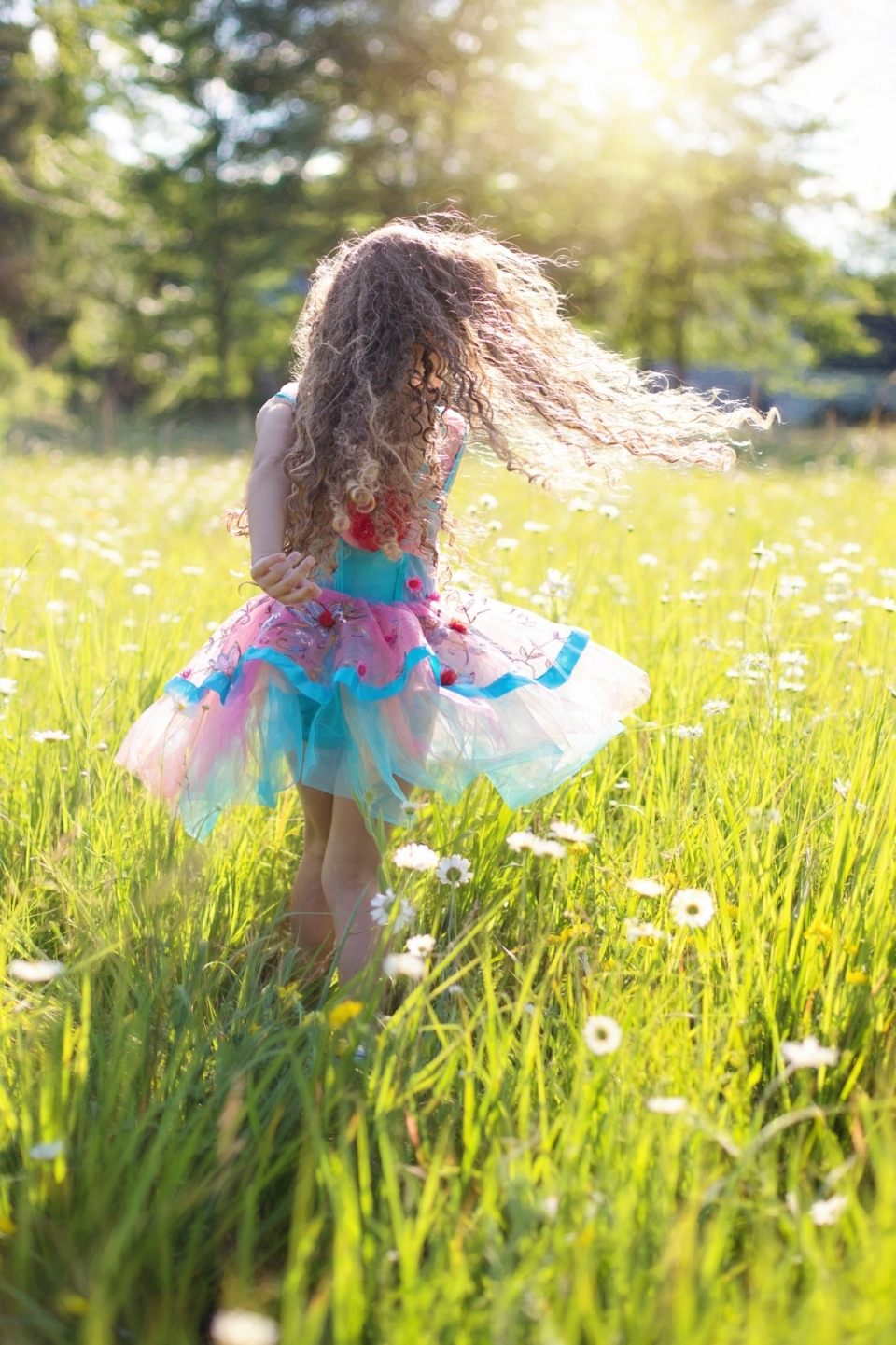 可爱金发小女孩在草地上花丛中奔跑