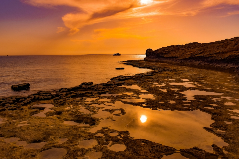 金黄色夕阳笼罩平静海滩自然美景