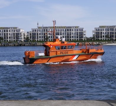 平静河面航行橘黄色船只