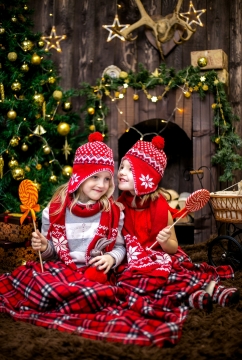 木屋毛毯上拿棒棒糖的红裙子女孩