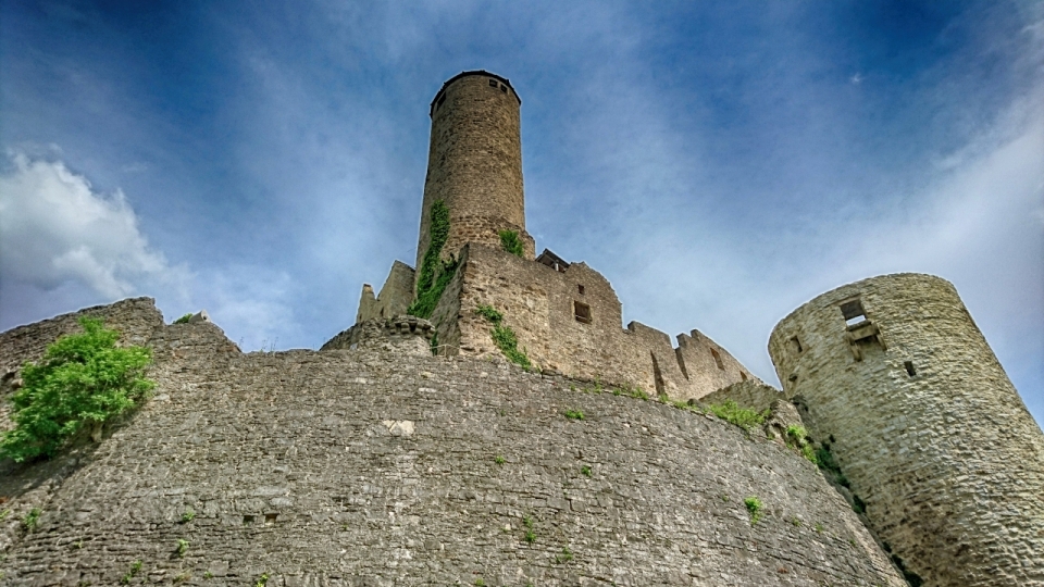 蓝天下长满青苔的废弃城堡建筑摄影