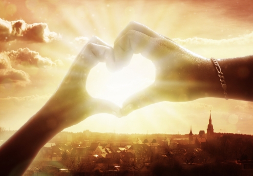 傍晚夕阳阳光光线穿透情侣比心手部